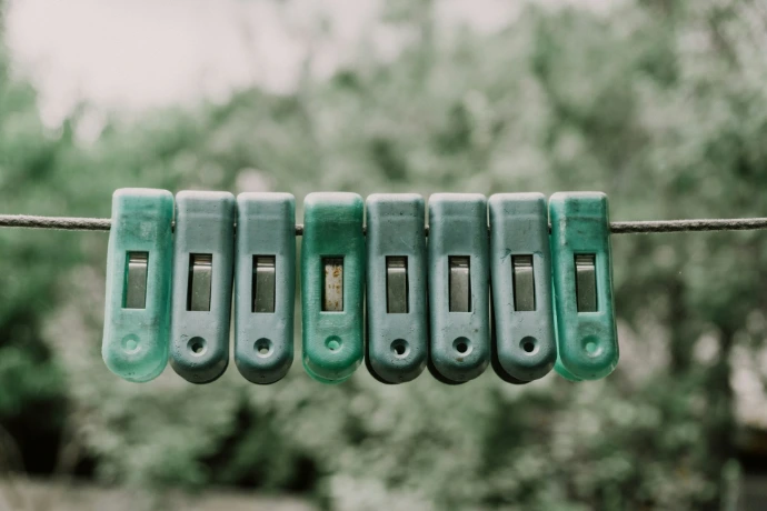 Green clothespins lined up on a wire